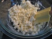 Transfer white chocolate chunks to large glass bowl and stir with plastic spatula.