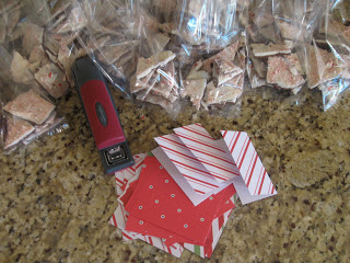 Using small pieces of festive paper and a stapler, assemble mini notes for bags of peppermint bark. 
