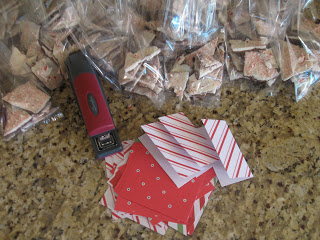 Using small pieces of festive paper and a stapler, assemble mini notes for bags of peppermint bark.