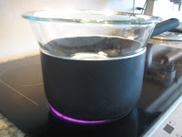 Warm crushed candy canes in a glass bowl over a boiling pot of water.