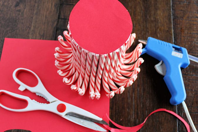 Looking for the perfect holiday centerpiece? This easy DIY candy cane vase is a budget-friendly project that will be the star of your holiday table!