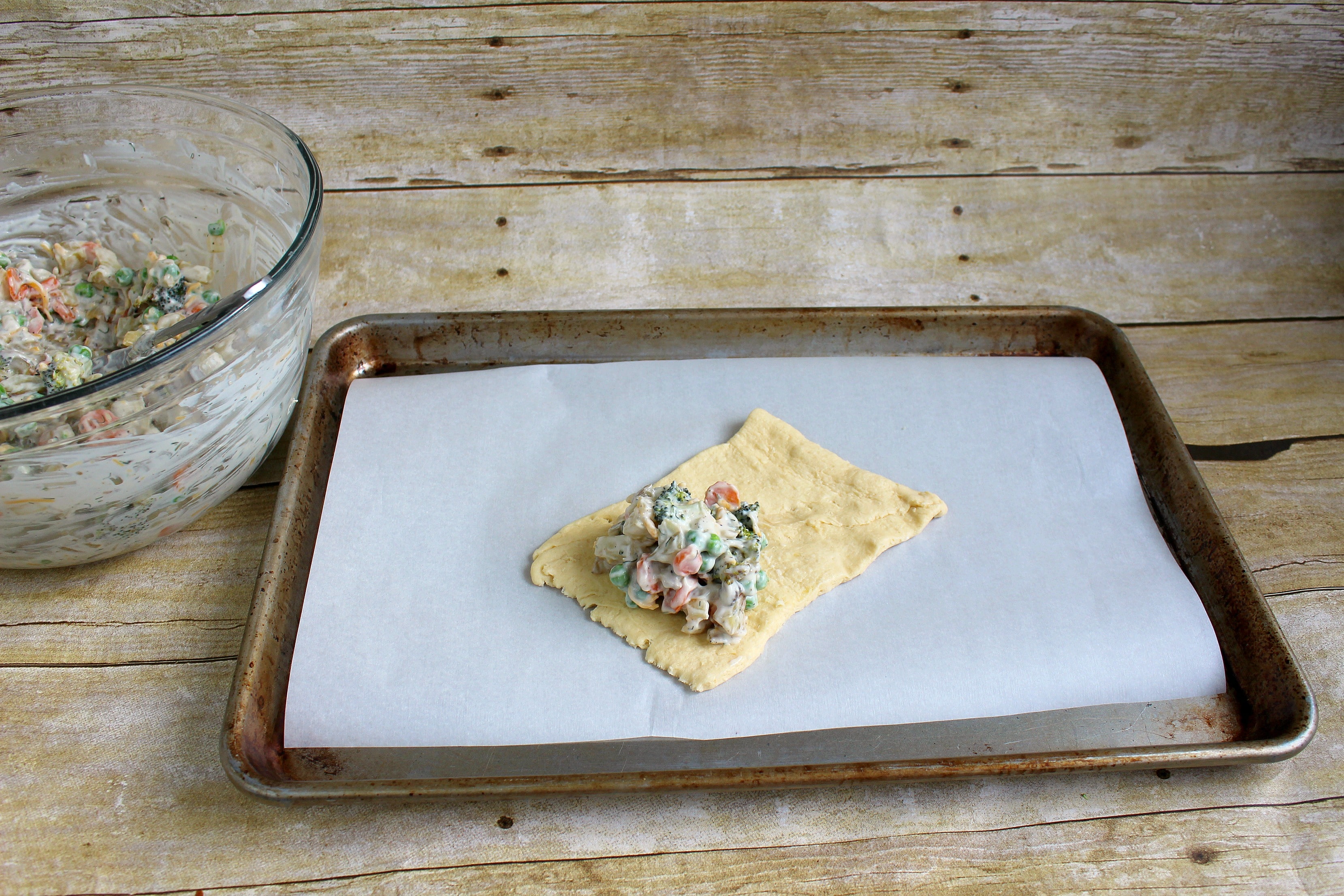 Step 6a of the Roasted Vegetable Pot Pie Pockets recipe is to unroll the crescent rolls and fill with the veggie mixture.