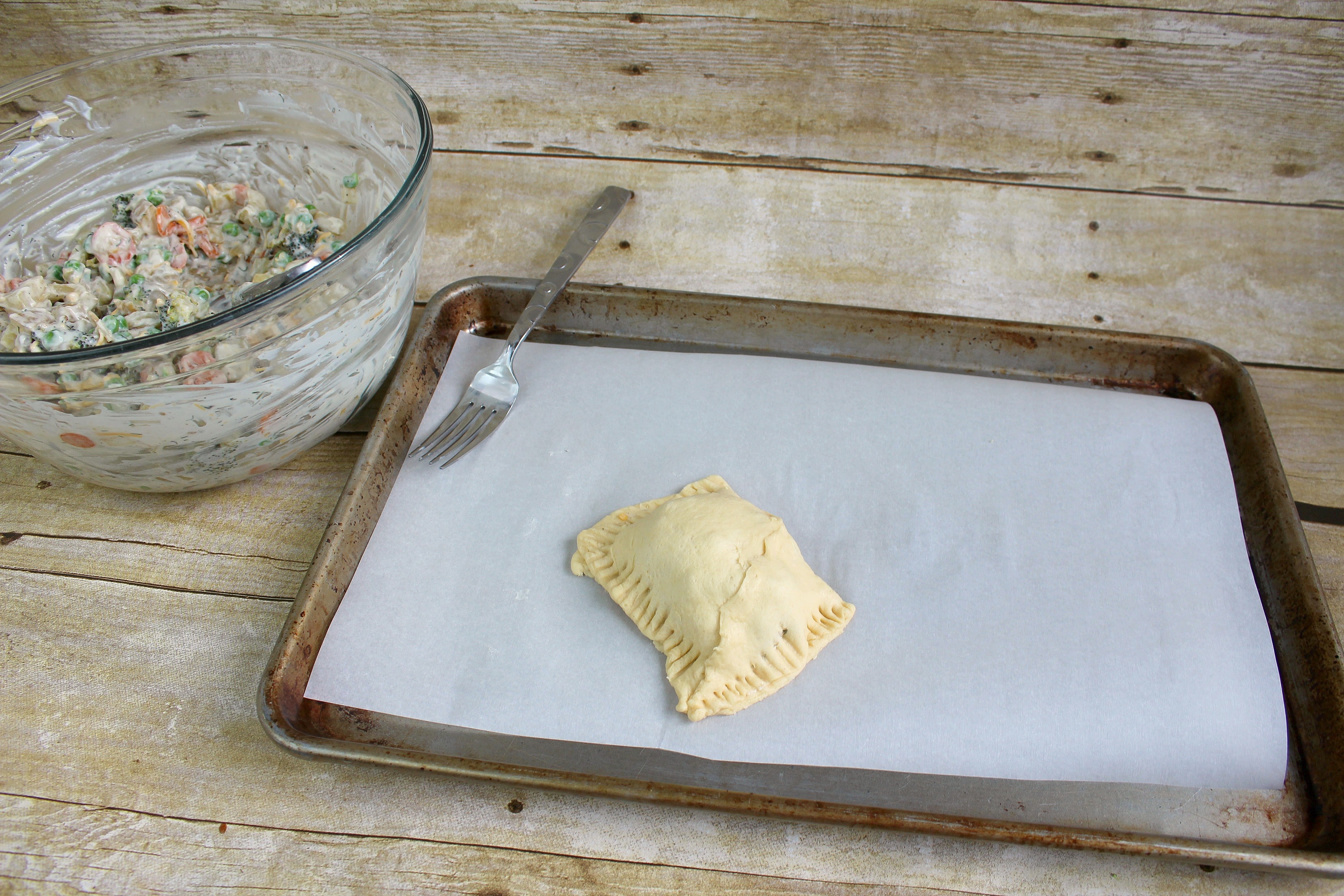 Step 6b of the Roasted Vegetable Pot Pie Pockets recipe is to fold the crescent roll over the mixture and seal all sides.