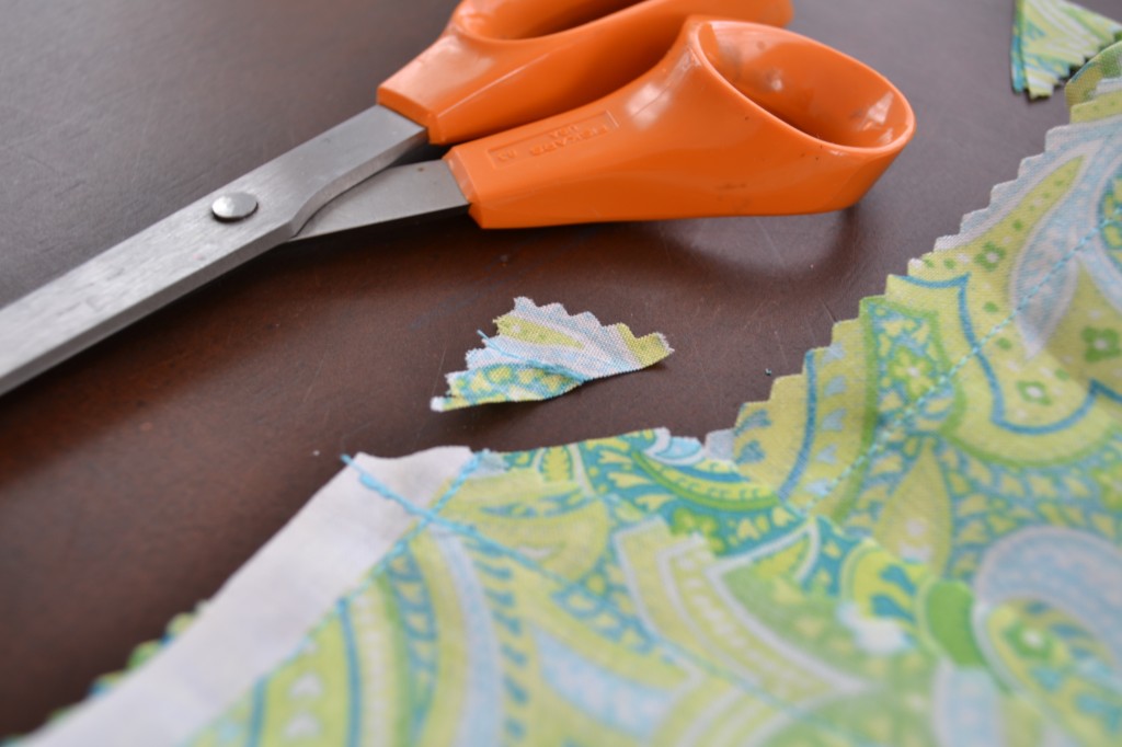 Snip the corners of the fabric with scissors, so your table runner will stay flat. 