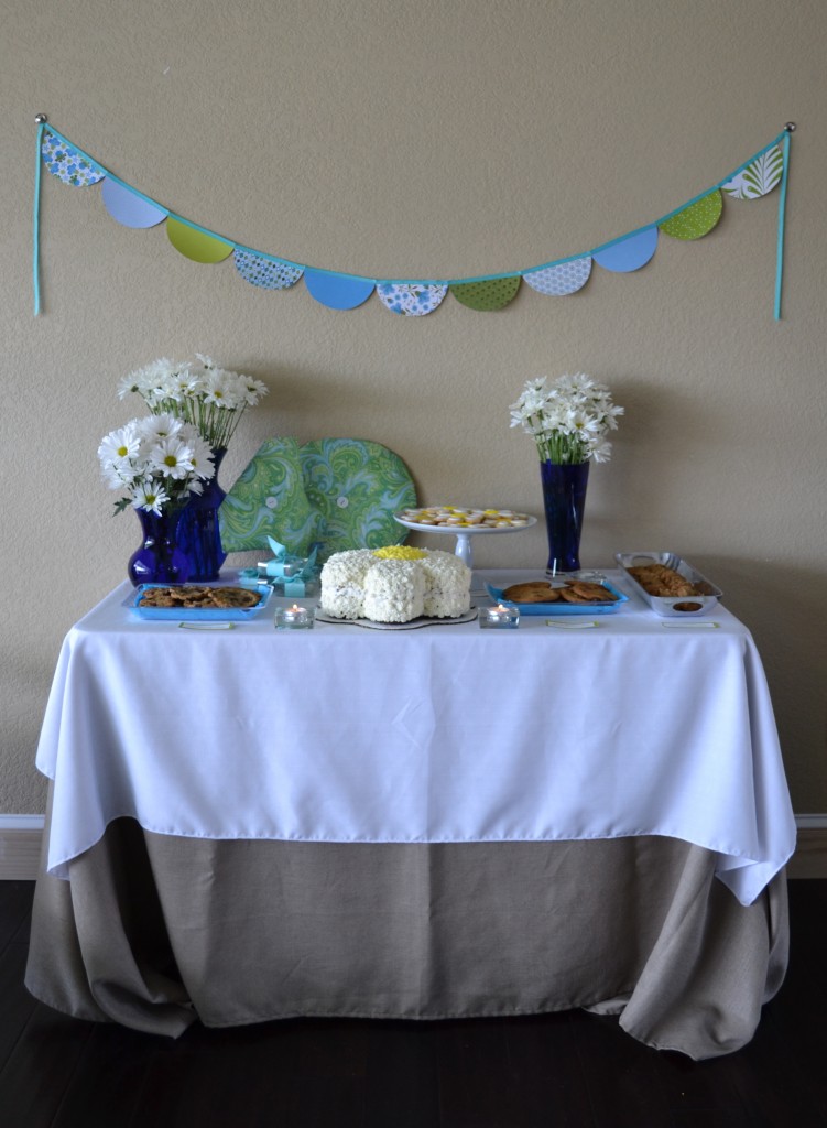 The DIY paper party garland above the dessert table is colorful.