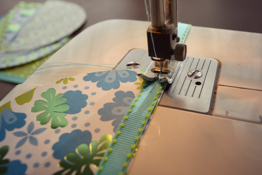 Sew ribbon onto the edges of your half circle pieces of paper stock. 