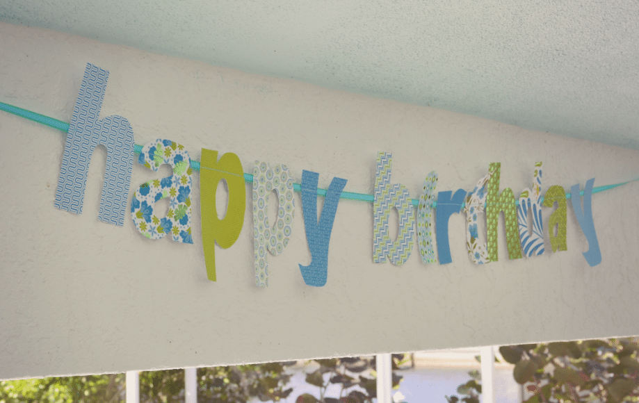Consider cutting out the pieces of paper stock into letters to create a festive sign. 