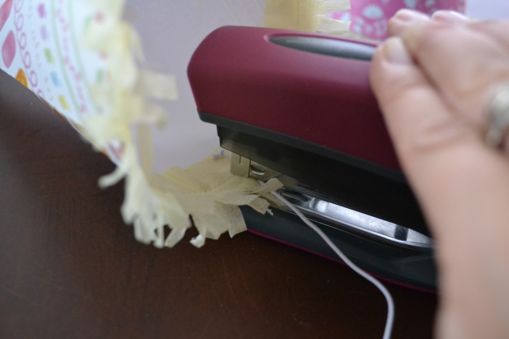 Secure the elastic to each party hat using a stapler. 