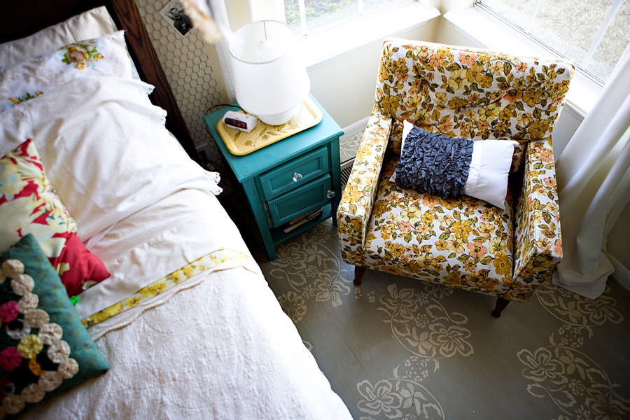 A coat of paint can update any piece, like this bright turquoise nightstand that looks fantastic in this boho style bedroom with vintage chair and pillows. 