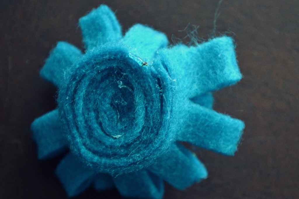 Roll flower tightly and glue in place with glue gun.