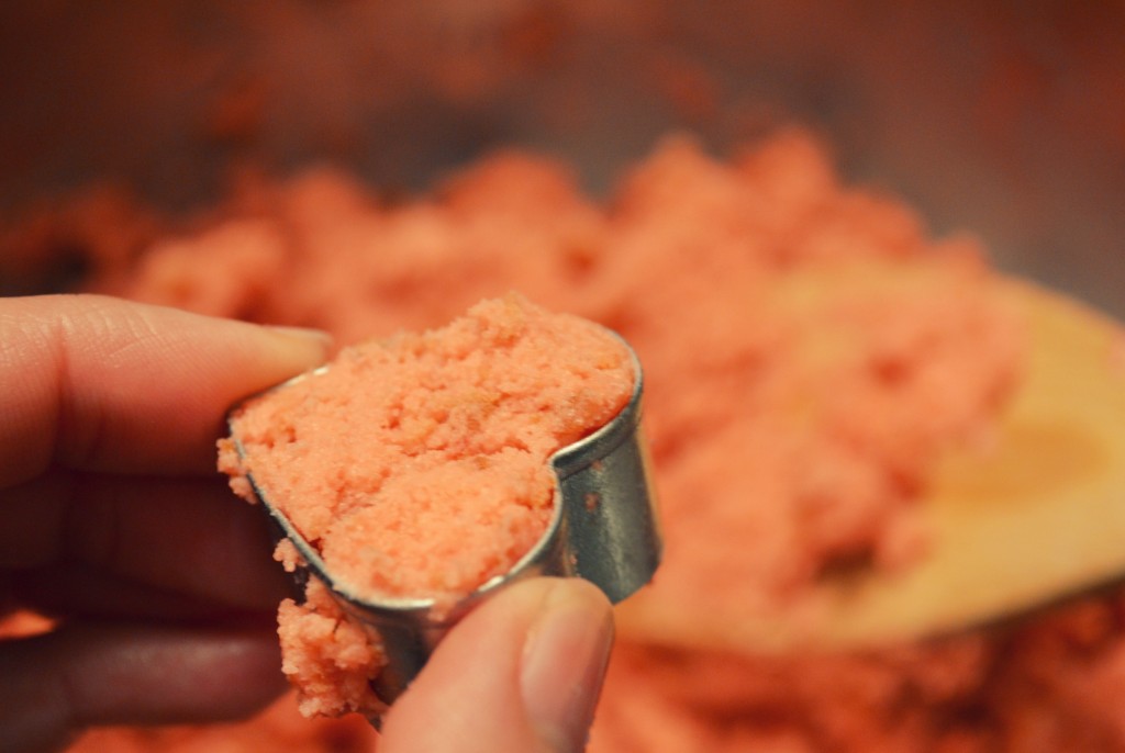 Begin making your Valentine's Day cake pops by pressing a lump of the crumb mixture into a heart shaped cookie cutter.