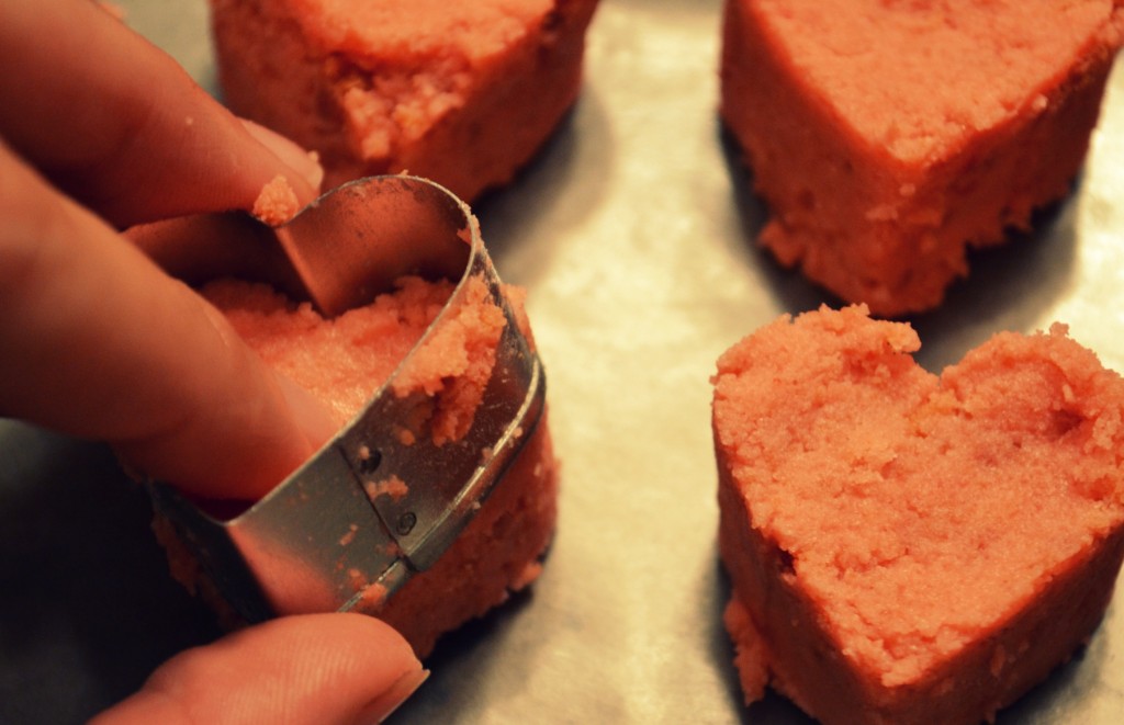 Press out heart shaped dough onto a wax-paper covered cookie sheet.  