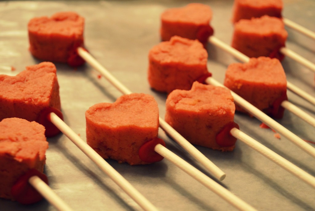 Add sticks to each of the heart shaped cake dough pieces. 