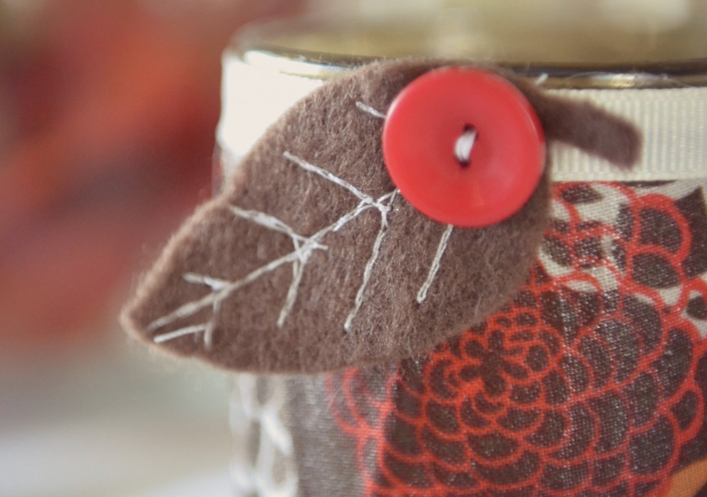 Add ribbon and the accent piece to the jar of your easy DIY Fabric-Covered Candle!