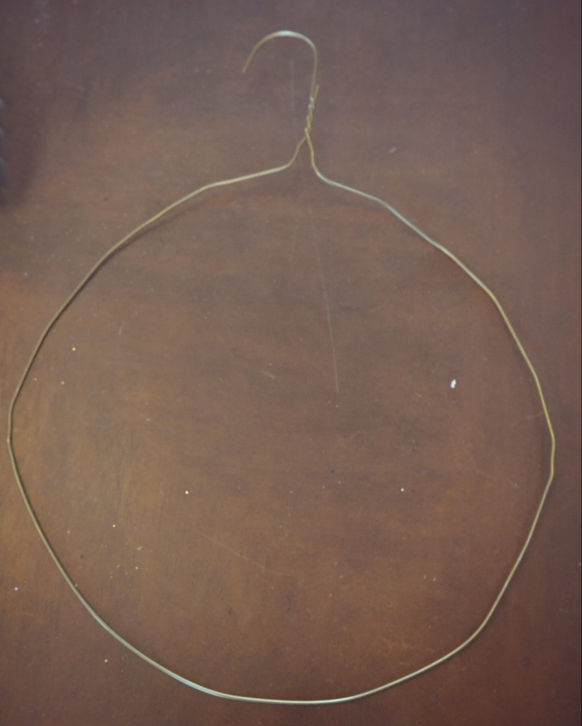 A wire hanger in the shape of a circle is the base for the ornament wreath. 