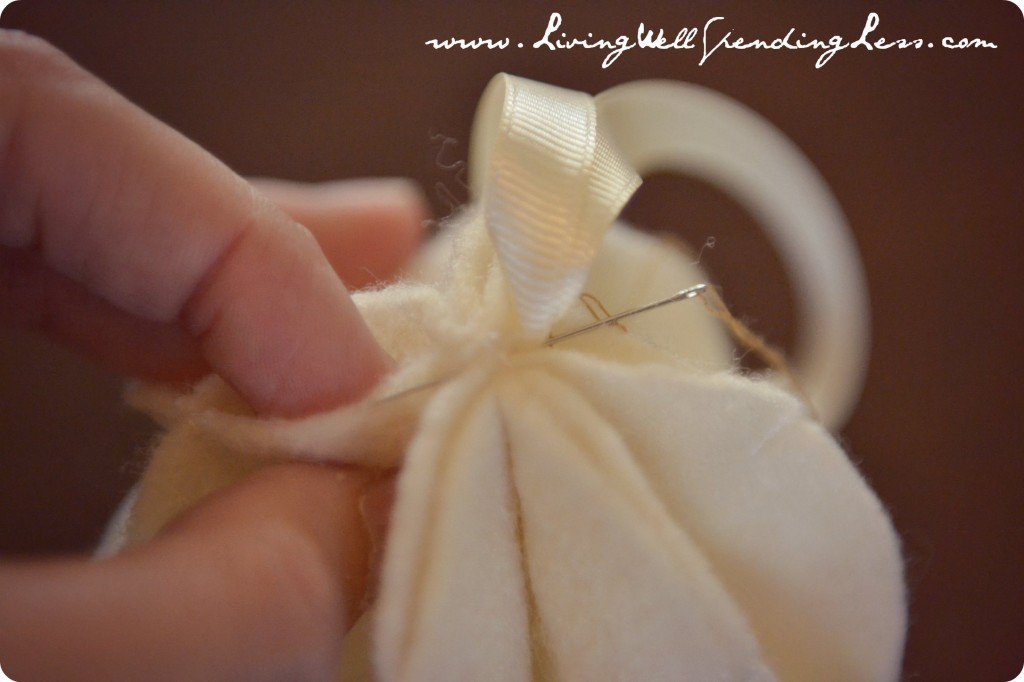 Using a needle and thread, stitch a loop of ribbon to the top of ornament.