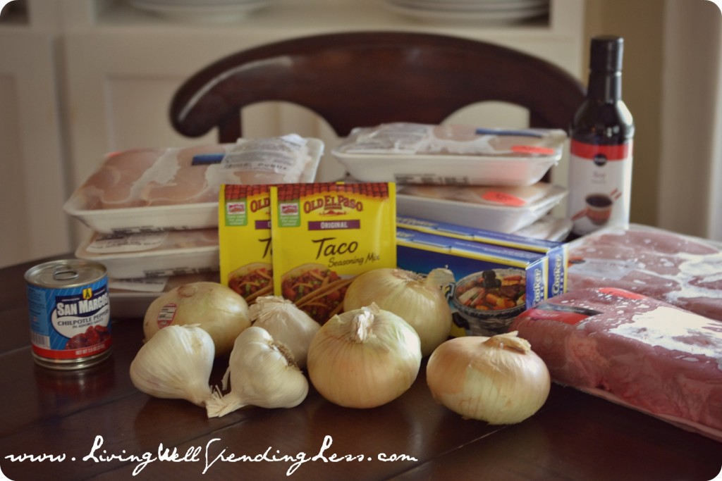 Assemble your various ingredients to begin freezer cooking meal prep: onions, garlic, meat, and more. 