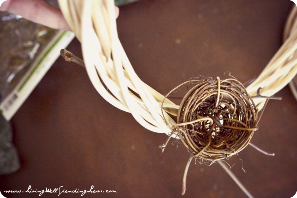 Twist the long stem of the decorative bird nest into the vines of the wreath. 