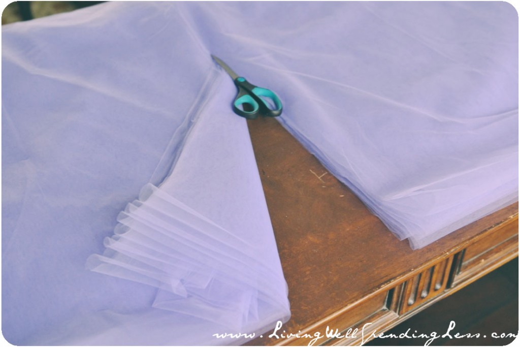 You can cut through several layers of tulle at once by folding it flat on the table. 