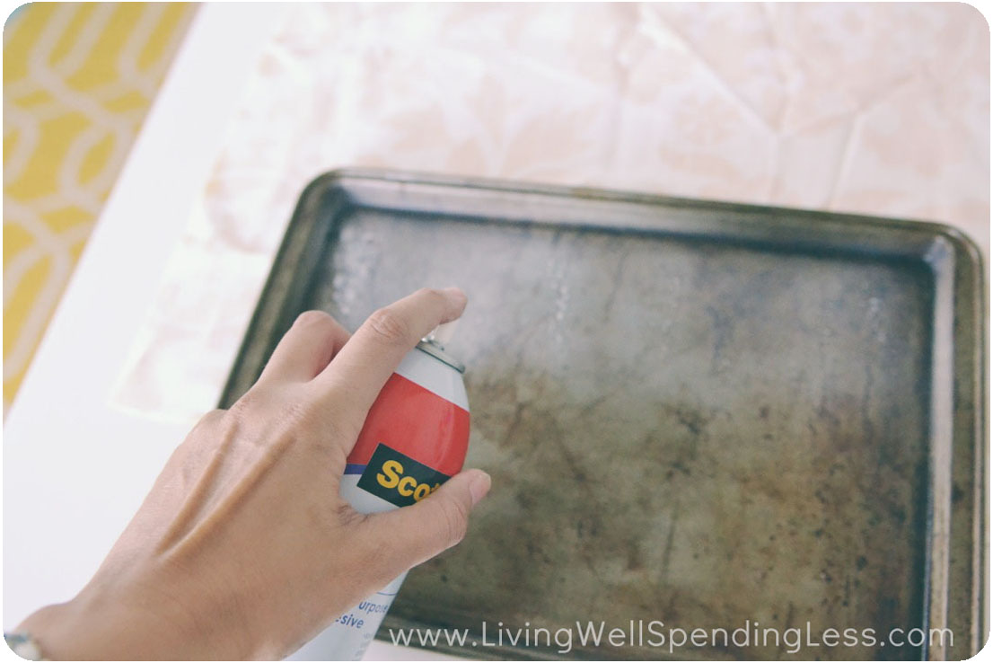 Spray the adhesive on the top and inner sides of the cookie sheet. 