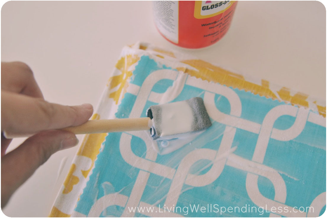 Brush the fabric on the back of the tray with Mod Podge. 