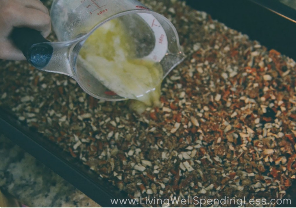 Spread the pretzel crumbs over the bottom of a pan and add melted butter to coat. 