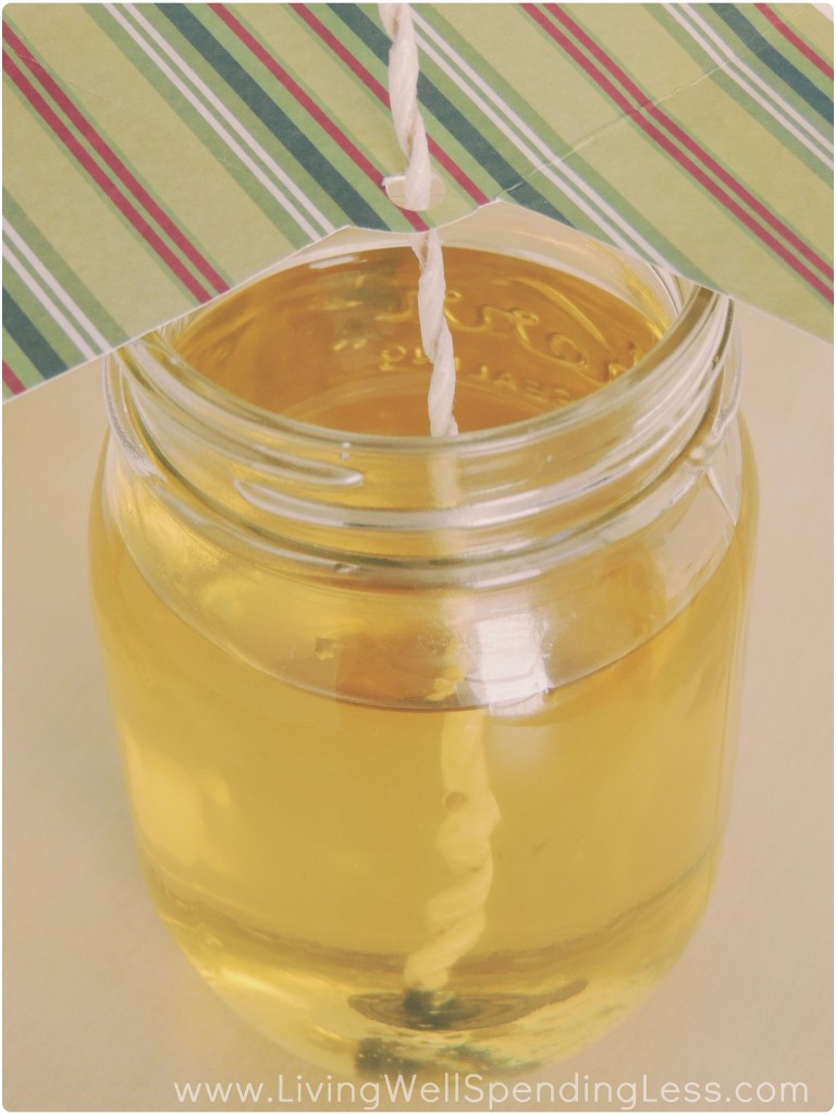 Pour the melted wax into your Mason jar, making sure the wick stays upright by using a piece of paper with a hole punched in it. 