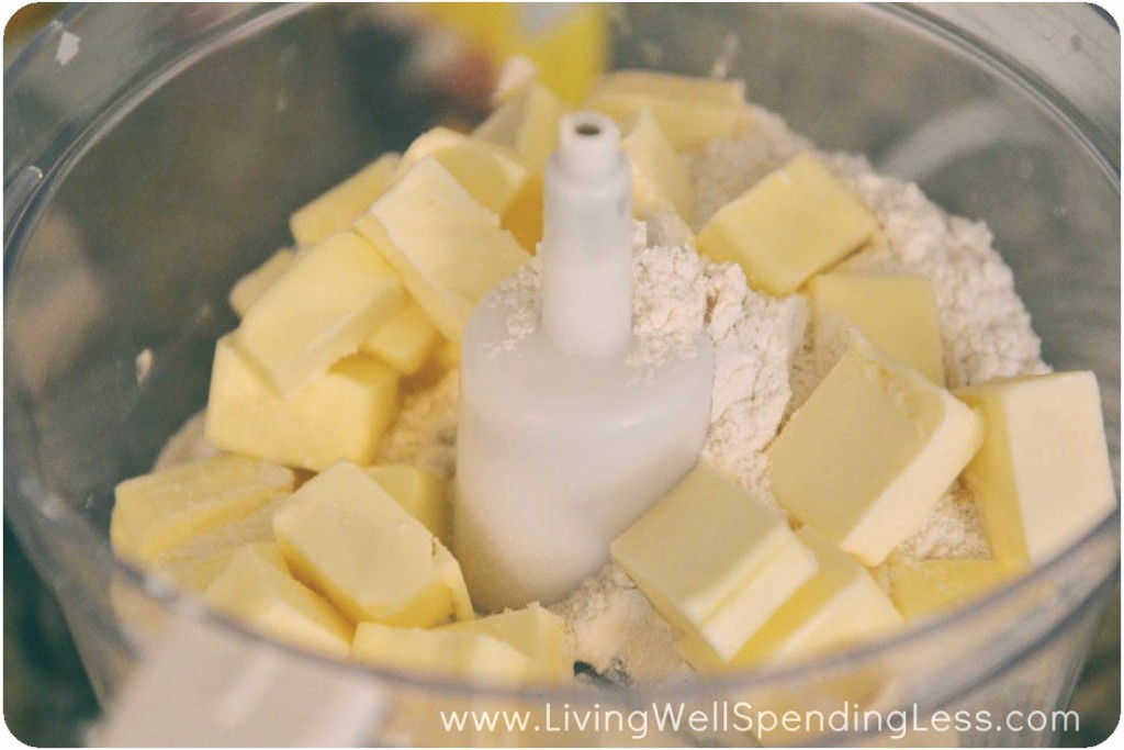 Place cubed butter, 2 cups flour, brown sugar, powdered sugar and salt in food processor 