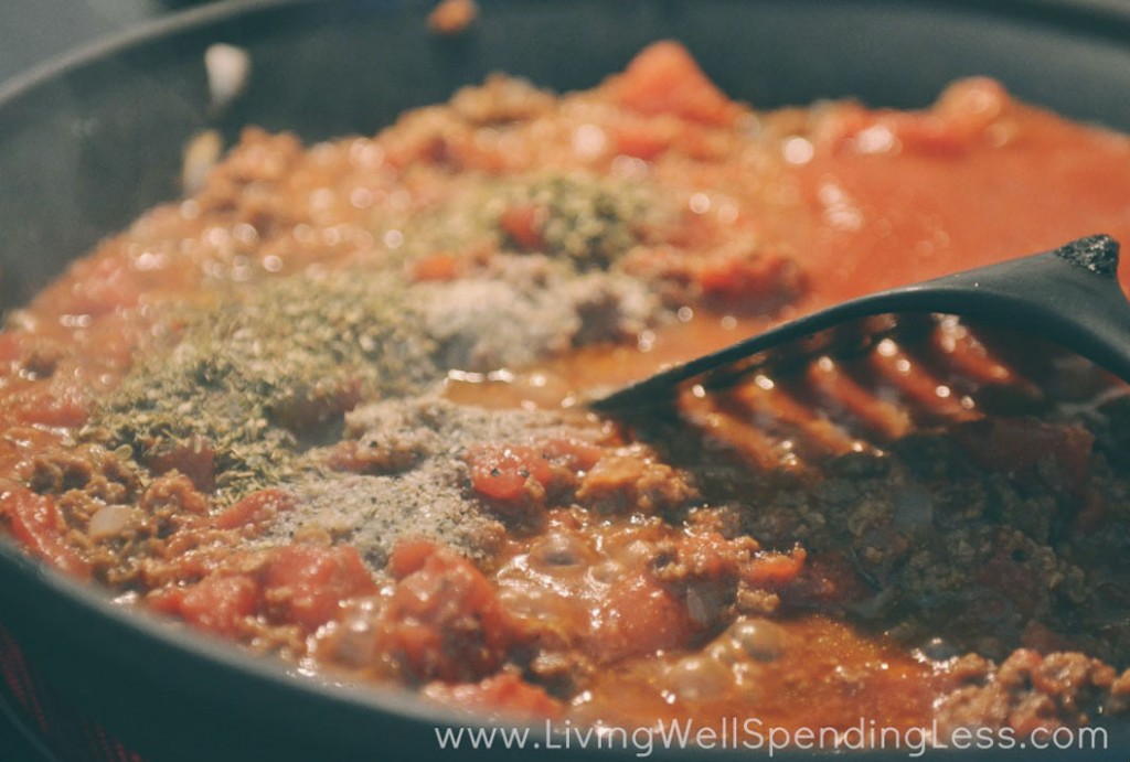 Add the tomato sauce and seasonings to the crumbles in the pan. 