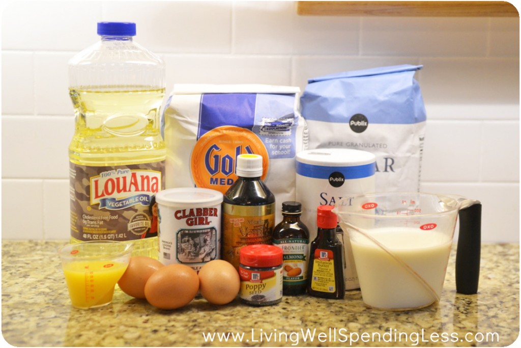 Assemble your ingredients for the orange almond poppy seed loaf: vegetable oil, orange juice, eggs, poppy seeds, vanilla extract, almond extract, flour, sugar, salt, milk, butter extract, and baking powder. 