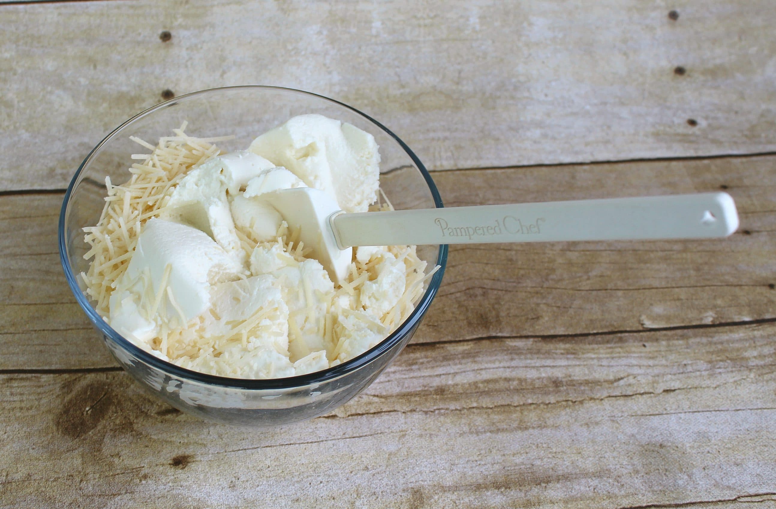 In bowl mix together ricotta and Parmesan cheeses.