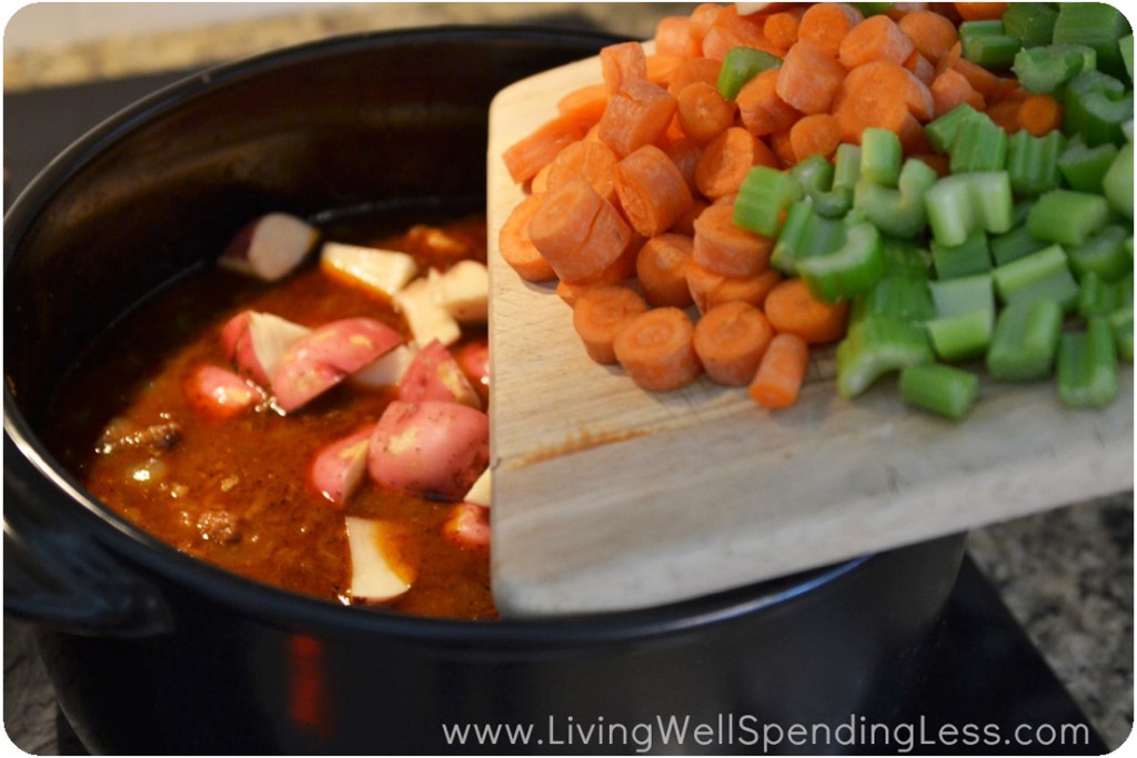 Chop carrots, potatoes and celery then add into pot. 