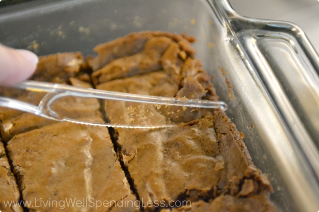 Cut baked brownies into 2x2 inch squares with plastic knife.