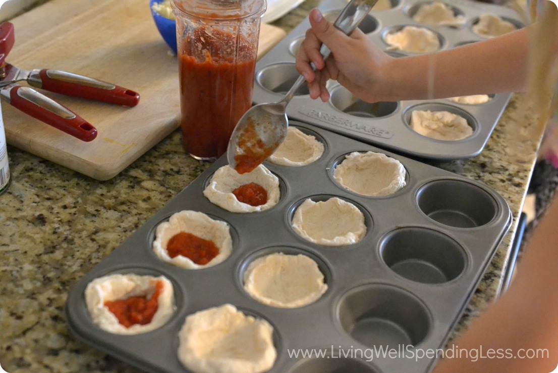 Spoon pizza sauce in biscuits 