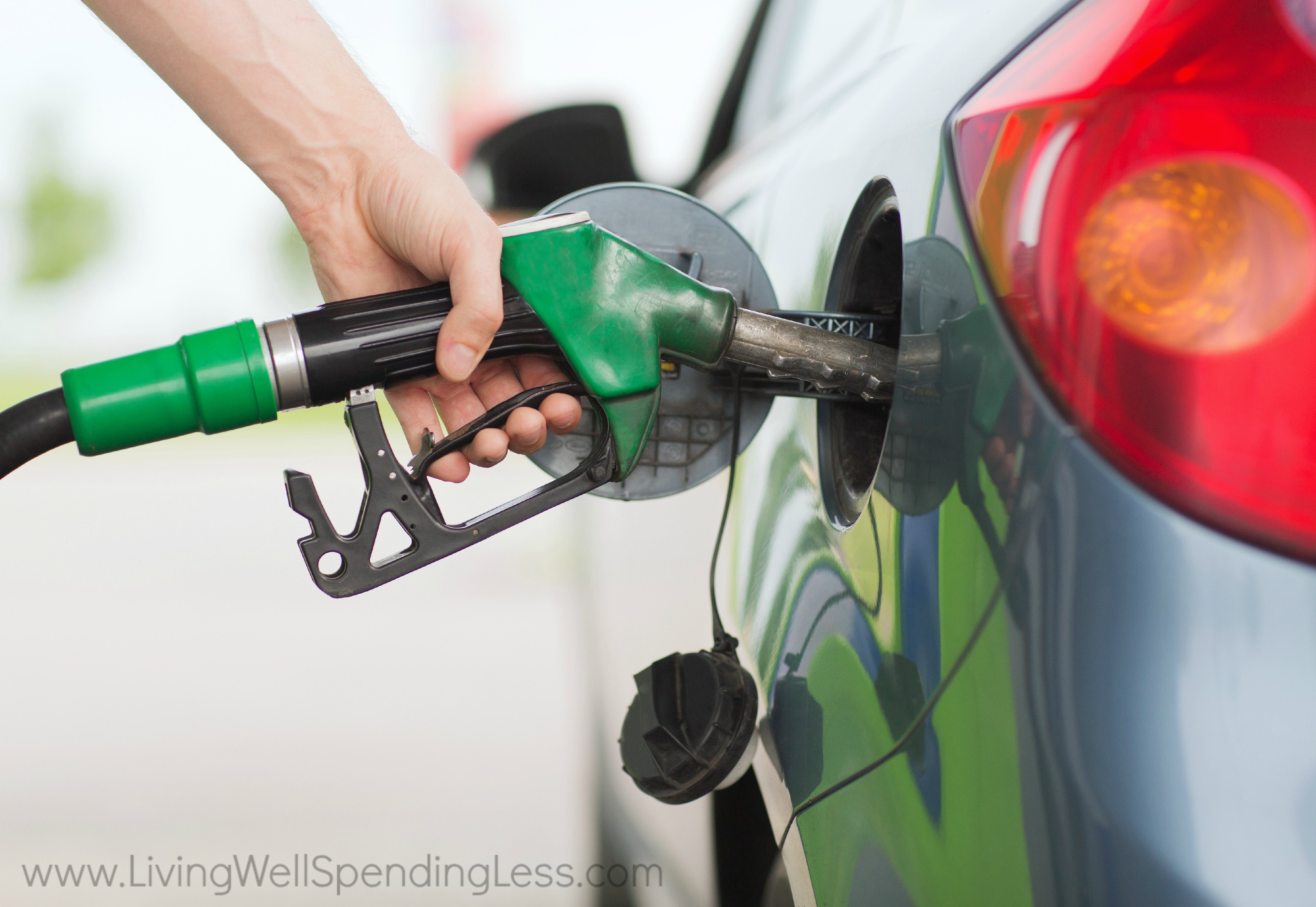 A man filling up his car with gas. 