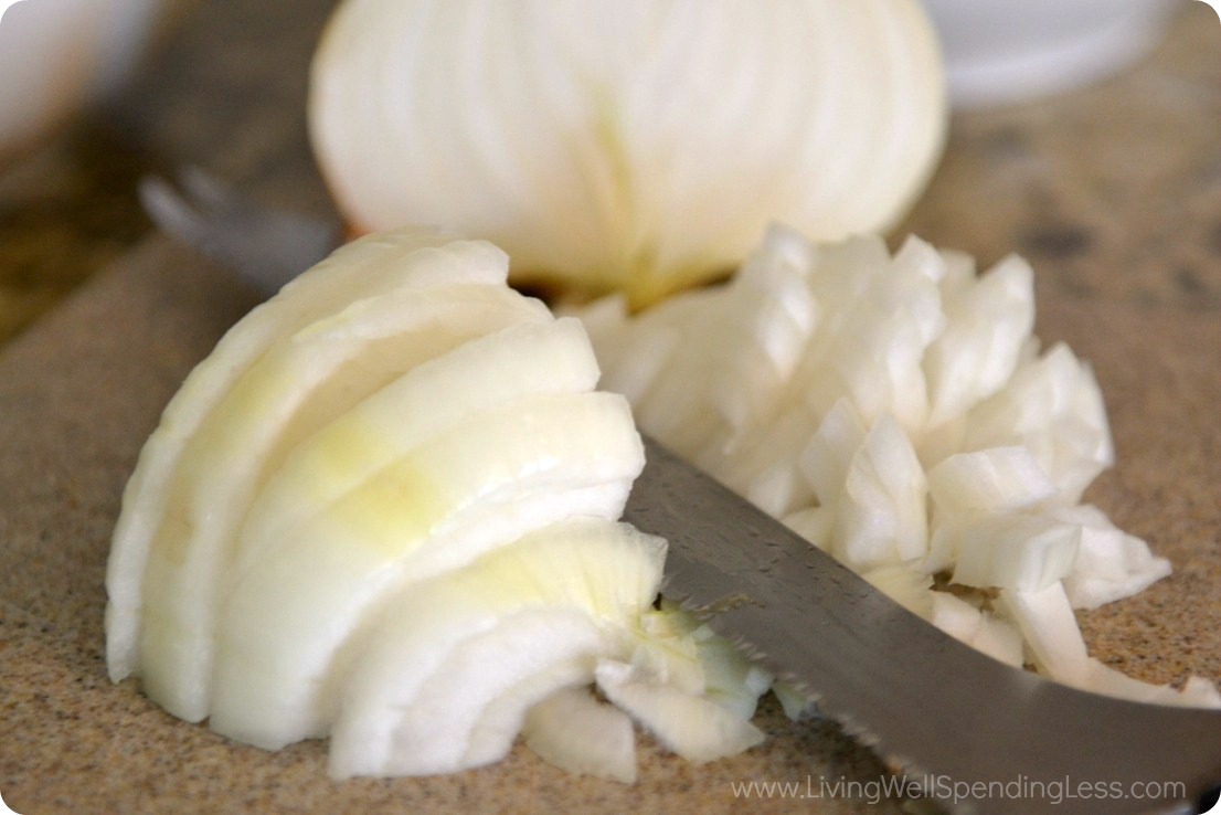 Dice a white onion using a kitchen knife. 