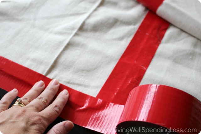 Tape a strip of duct tape and fold it along the edge of the canvas drop cloth to reinforces the edges of the cloth. 