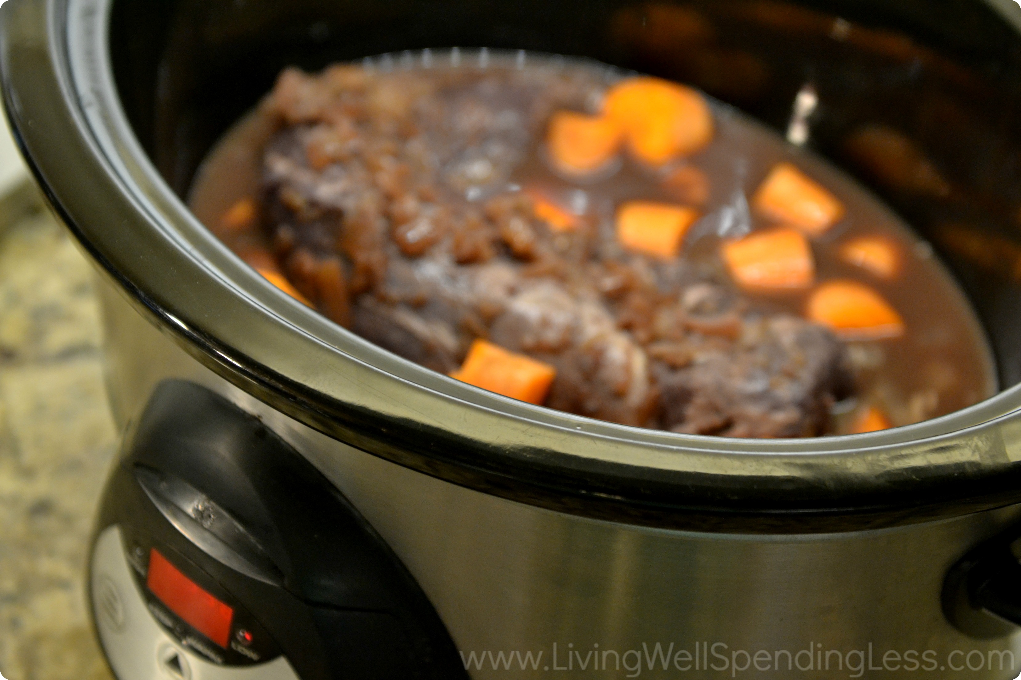 When you're ready to cook, add the meat to the slow cooker along with chopped carrots. 