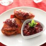 This deceptively easy dish makes everyday feel like a holiday! Moist, juicy, and full of flavor, this simple cranberry chicken whips up in minutes with just a few basic ingredients, and is freezer and crockpot friendly too! #recipes #chickenrecipes #cranberryrecipes #cranberrychicken #holidayrecipes #freezerrecipes #crockpotrecipes #slowcookerrecipes