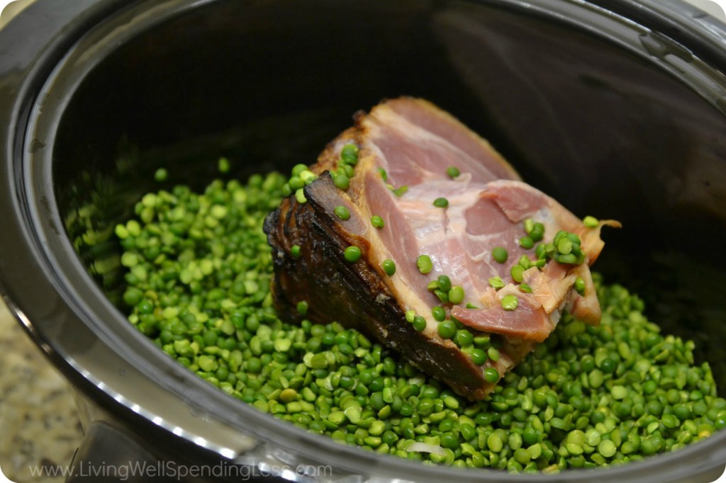Add ham bone and split peas into slow cooker. 