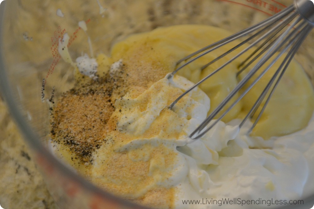 Next step in this Cheesy Potato Casserole is to whisk together the soup, sour cream, butter, salt, and garlic powder.