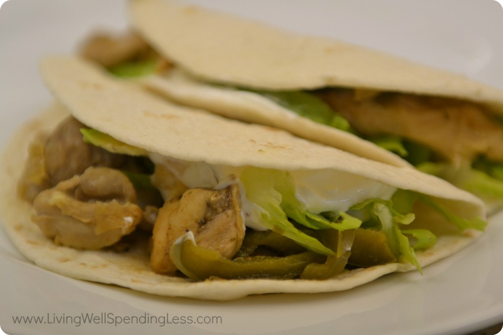 Serve cooked fajitas with tortillas garnished with sour cream and lettuce. 