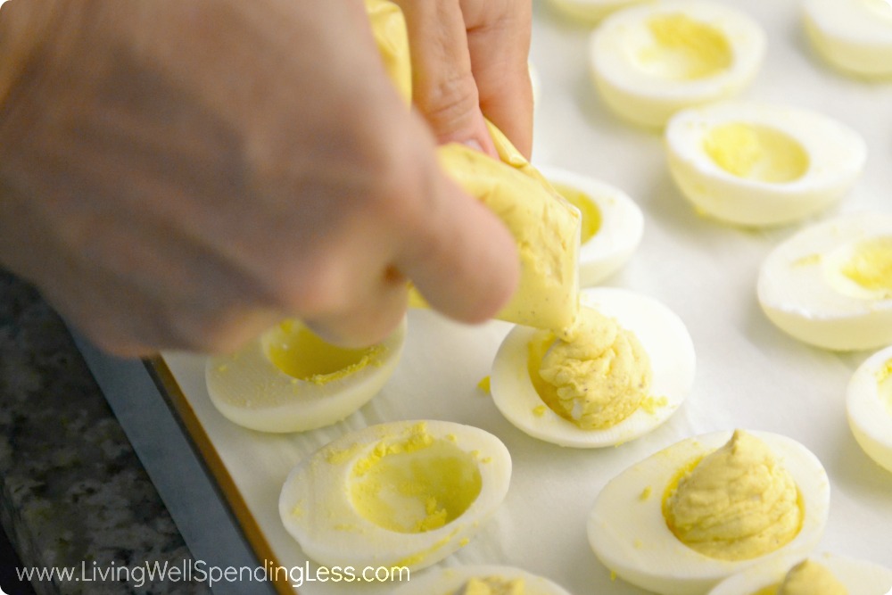 Spoon mixture into ziplock bag then cut a small hole to squeeze out mixture into egg white halves.