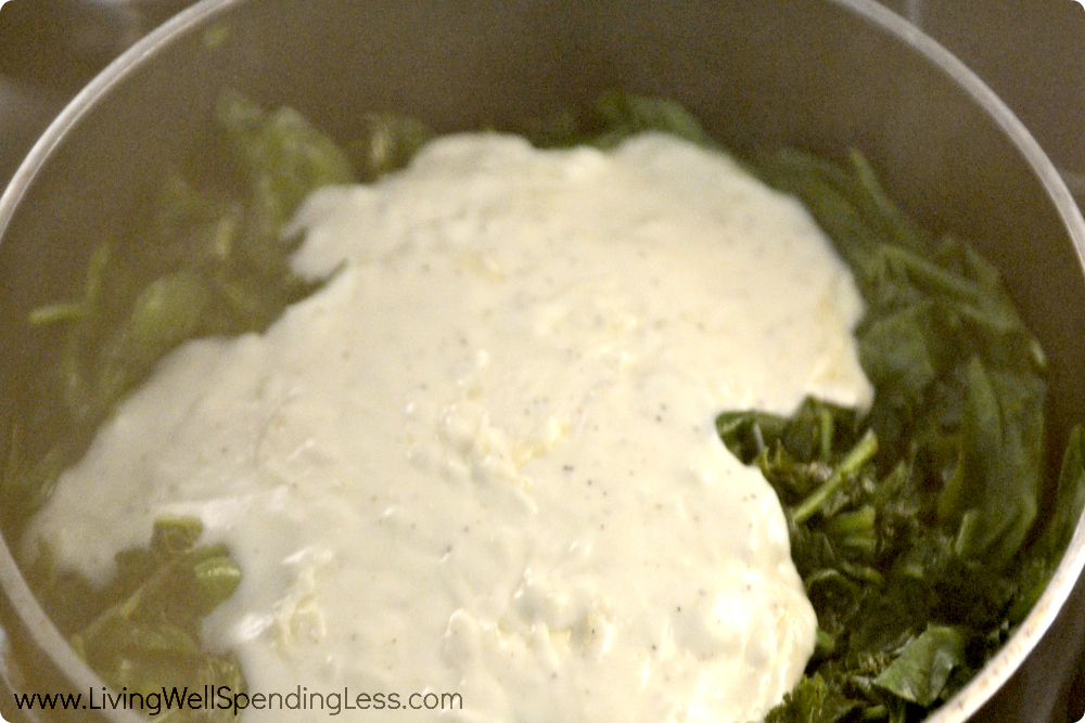 Add the creamy sauce to the sauteed spinach and kale. 