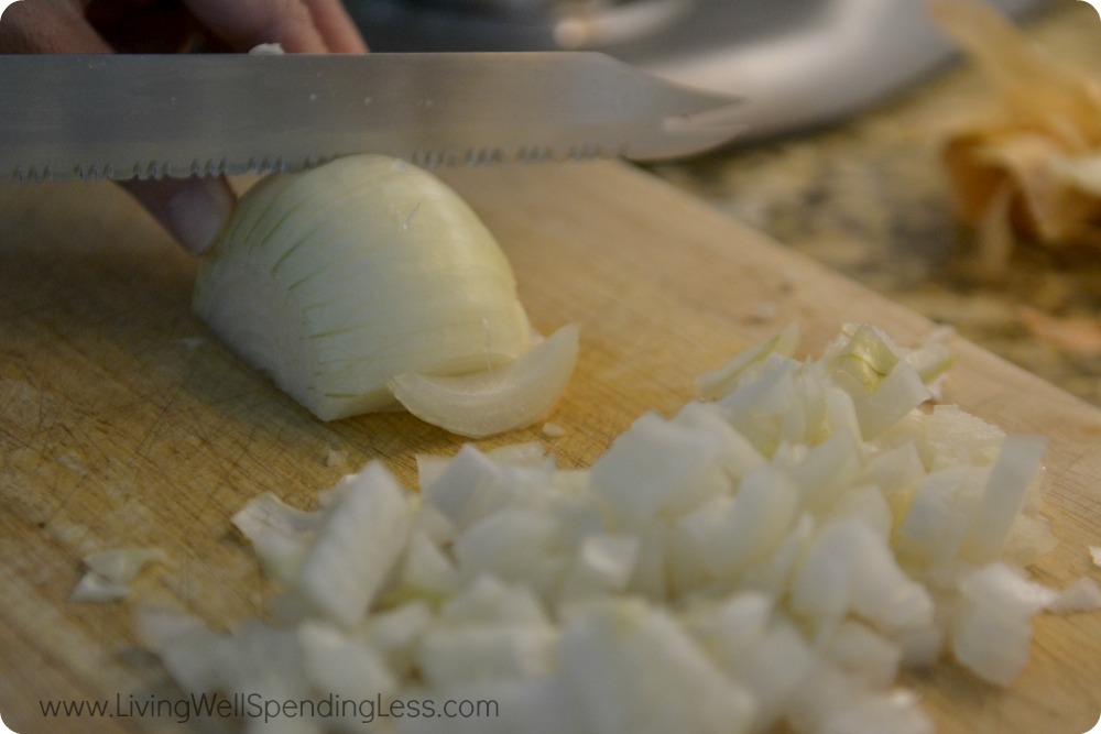 Dice a white onion into small pieces for the base of this kale and white bean soup.
