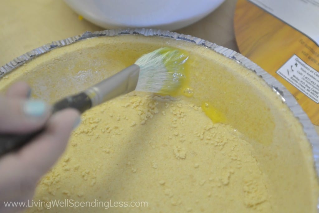 Brush bottom and sides of crust with egg yolk.