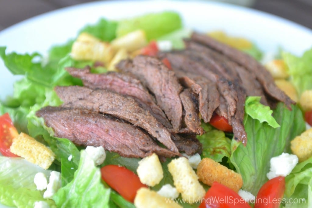 Serve sliced seasoned steak over salad. 