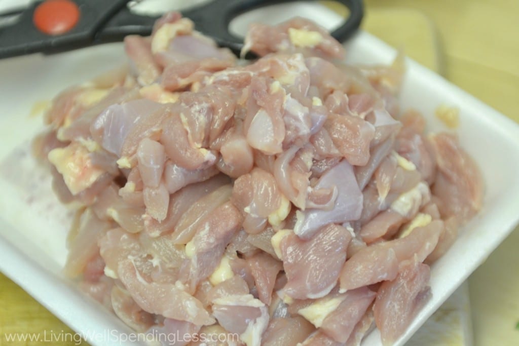 Cut the raw chicken into strips using a knife or kitchen shears.