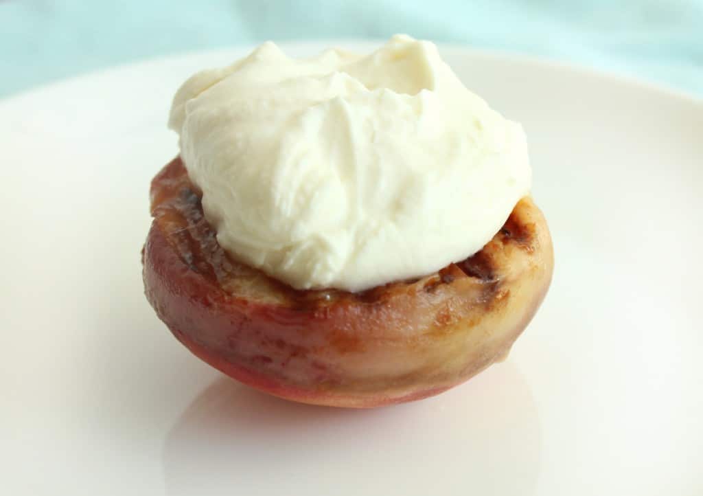 While the grilled peaches are still warm, add the whipped marscapone topping. 