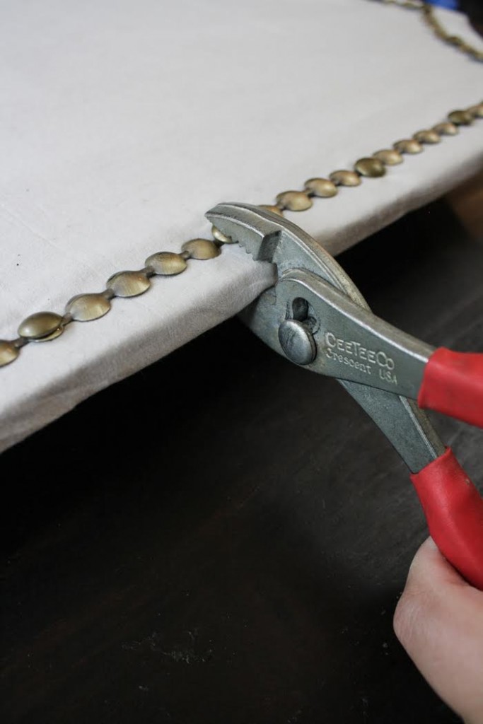 Use wire cutters to secure the nail head trim to the cork board. 